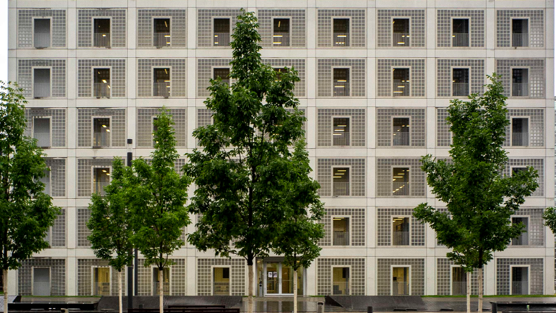 Die Stadtbibliothek am Mailänder Platz zeigt eine moderne, quadratische Fassade mit symmetrischen Fenstern. Vor dem Gebäude stehen mehrere Bäume., © Stuttgart-Marketing GmbH, Frank Hörner