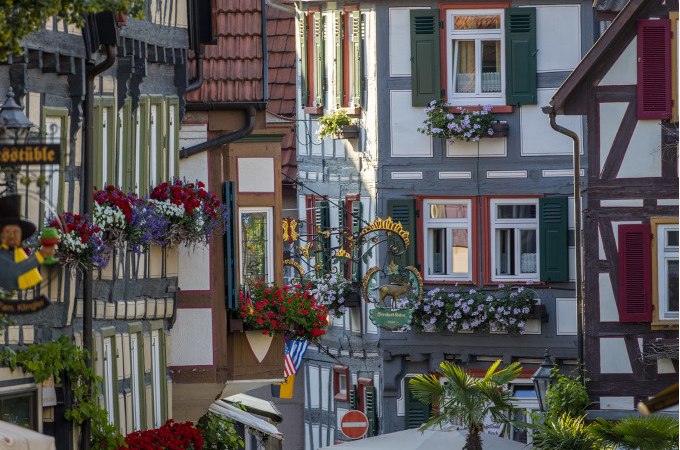 Fachwerkhäuser mit bunten Fensterläden und Blumenkästen in einer malerischen deutschen Altstadt. Einladende Atmosphäre mit historischen Details., © Stadt Besigheim Fachwerkhäuser mit bunten Fensterläden und Blumenkästen in einer malerischen deutschen Altstadt. Einladende Atmosphäre mit historischen Details., © Stadt Besigheim