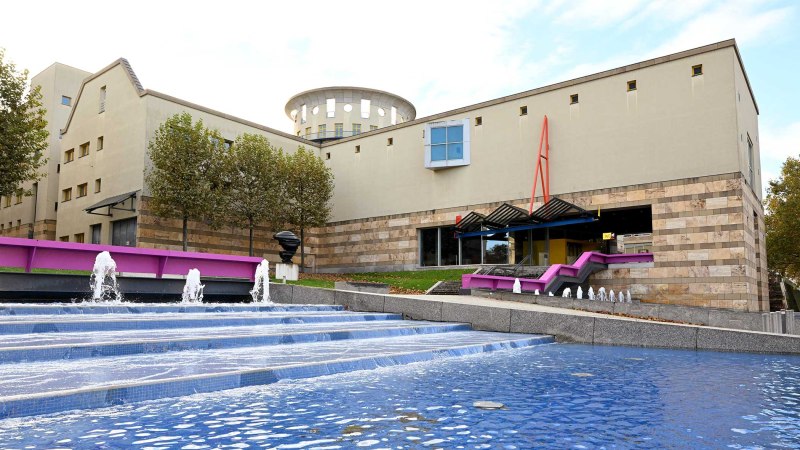 Das Haus der Geschichte zeigt moderne Architektur mit einem Brunnen im Vordergrund. Bäume säumen das Gebäude, das durch klare Linien und Farben besticht., © Haus der Geschichte Baden-Württemberg Das Haus der Geschichte zeigt moderne Architektur mit einem Brunnen im Vordergrund. Bäume säumen das Gebäude, das durch klare Linien und Farben besticht., © Haus der Geschichte Baden-Württemberg