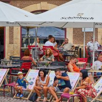Menschen sitzen unter Sonnenschirmen vor dem FRIEDRICH Café in Waldenbuch. Kinder und Erwachsene entspannen auf Stühlen und Liegestühlen., © thomas ceska waldenbuch