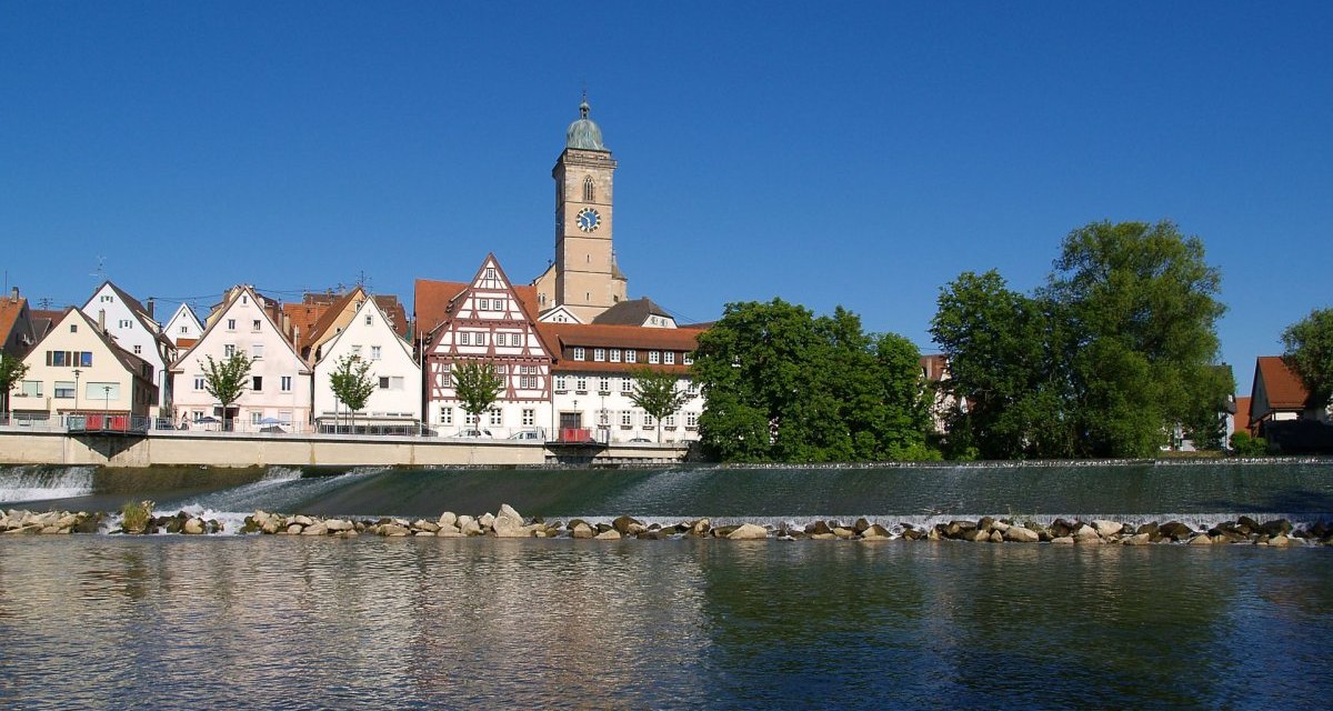 Fachwerkhäuser und ein Kirchturm in Nürtingen spiegeln sich im Fluss unter blauem Himmel wider., © Stadt Nürtingen Fachwerkhäuser und ein Kirchturm in Nürtingen spiegeln sich im Fluss unter blauem Himmel wider., © Stadt Nürtingen