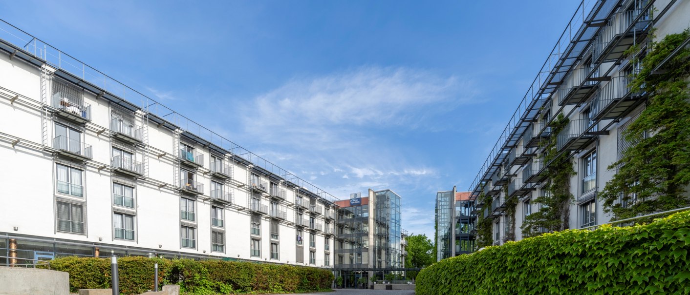 Zwei moderne Gebäude mit Glasfassaden und Balkonen, die einen Innenhof bilden. Der Himmel ist klar und blau, umgeben von grüner Vegetation., © Plaza Residence Stuttgart-Ditzingen Zwei moderne Gebäude mit Glasfassaden und Balkonen, die einen Innenhof bilden. Der Himmel ist klar und blau, umgeben von grüner Vegetation., © Plaza Residence Stuttgart-Ditzingen