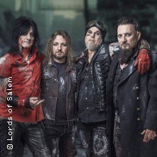 Vier M&auml;nner in rockiger Kleidung posieren vor einem unscharfen Hintergrund. Sie tragen Lederjacken und haben lange Haare., &copy; links im Bild