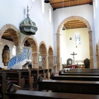 Innenansicht der Evangelischen Stiftskirche Bad Boll mit Holzbänken, einer verzierten Kanzel und einem Altar mit Kreuz., © Landkreis Göppingen