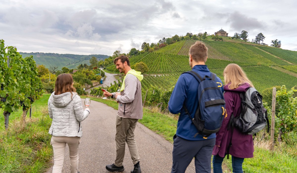 Menschen wandern auf einem Weinweg, halten Weingläser. Im Hintergrund Weinberge und die Grabkapelle auf einem Hügel., © Stuttgart-Marketing GmbH, Martina Denker Menschen wandern auf einem Weinweg, halten Weingläser. Im Hintergrund Weinberge und die Grabkapelle auf einem Hügel., © Stuttgart-Marketing GmbH, Martina Denker