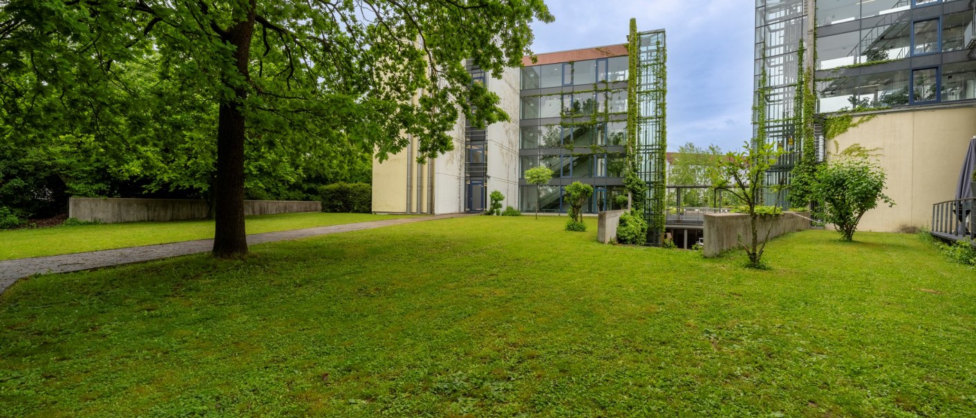 Grüne Wiese mit Bäumen und modernen Gebäuden im Hintergrund. Die Gebäude haben Glasfassaden und sind von Pflanzen umgeben., © Plaza Residence Stuttgart-Ditzingen Grüne Wiese mit Bäumen und modernen Gebäuden im Hintergrund. Die Gebäude haben Glasfassaden und sind von Pflanzen umgeben., © Plaza Residence Stuttgart-Ditzingen