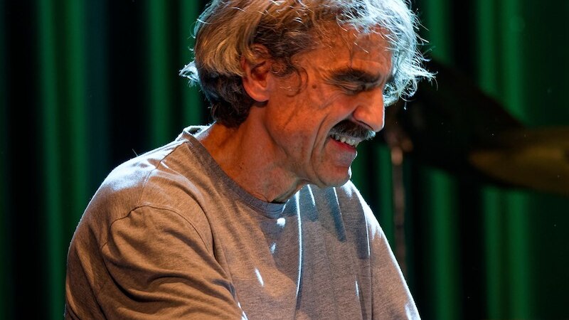 Ein Mann spielt Klavier auf einer B&uuml;hne. Er tr&auml;gt ein graues Shirt und wirkt konzentriert. Der Hintergrund ist gr&uuml;n beleuchtet., &copy; Thomas Scheytt