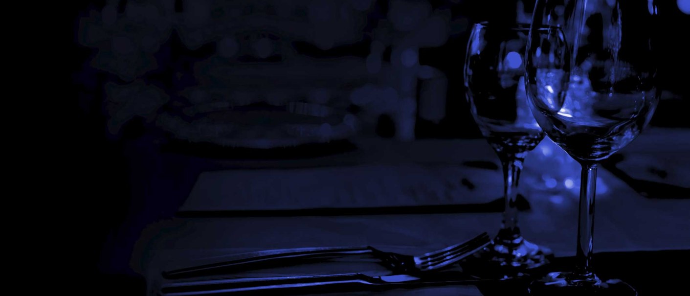 Ein dunkler, stimmungsvoller Tisch mit Weingläsern und Besteck, beleuchtet von schwachem blauen Licht., © EINS + Alles/Christopherus e. V. Ein dunkler, stimmungsvoller Tisch mit Weingläsern und Besteck, beleuchtet von schwachem blauen Licht., © EINS + Alles/Christopherus e. V.