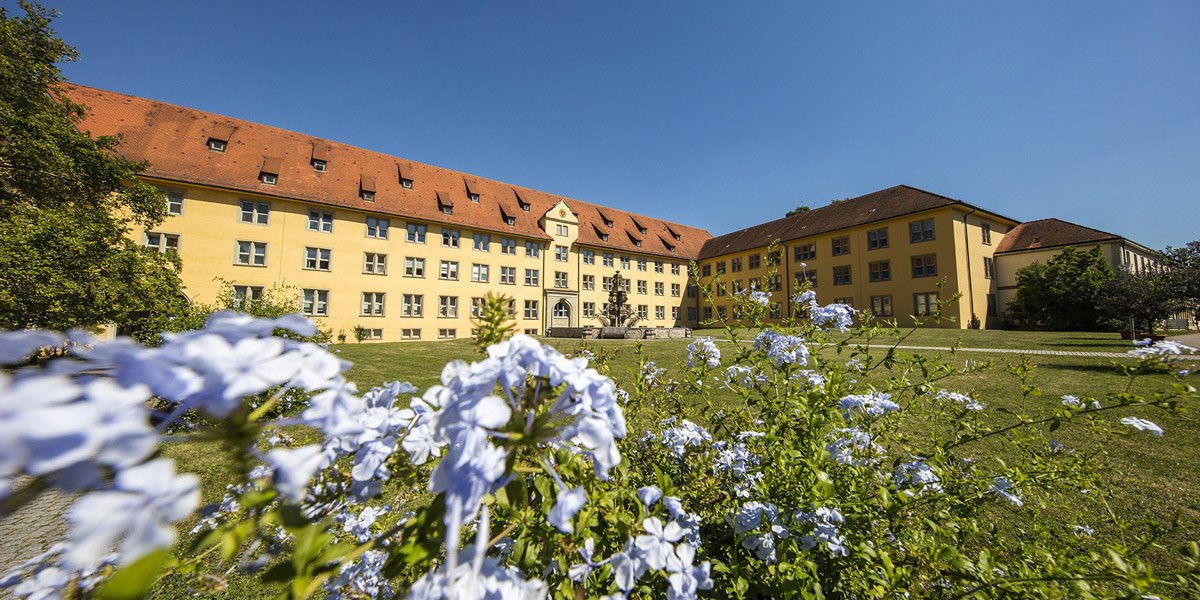 Schloss Winnental mit gelber Fassade und rotem Dach, umgeben von blühenden Blumen und grünem Rasen unter blauem Himmel., © Stuttgart-Marketing GmbH, Achim Mende Schloss Winnental mit gelber Fassade und rotem Dach, umgeben von blühenden Blumen und grünem Rasen unter blauem Himmel., © Stuttgart-Marketing GmbH, Achim Mende