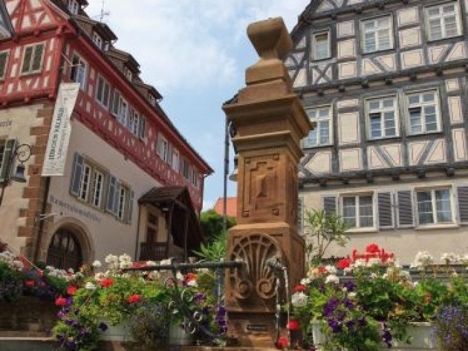 Fachwerkh&auml;user und ein Brunnen in Waiblingen, umgeben von bunten Blumen. Traditionelle Architektur und sommerliche Atmosph&auml;re., &copy; WTM GmbH Waiblingen