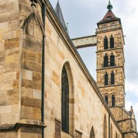 Die Stadtkirche St. Dionys in Esslingen zeigt gotische Architektur mit markanten Fenstern und einem hohen Turm. Im Hintergrund sind Fachwerkh&auml;user zu sehen., &copy; Stuttgart-Marketing GmbH, Sarah Schmid