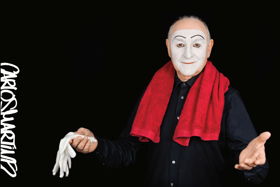 Ein Mann mit weiß geschminktem Gesicht, rotem Handtuch um den Hals und schwarzen Hemd hält weiße Handschuhe. Links steht "Carlos Martinez" geschrieben., © Carlos Martinez ©Bernd Eidenmueller