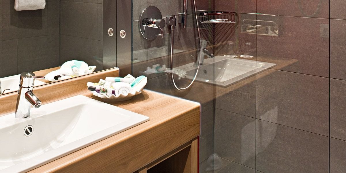 Modernes Badezimmer mit Waschbecken, Spiegel, Duschbereich und Pflegeprodukten auf dem Waschtisch., © Mercure Stuttgart Airport Messe Modernes Badezimmer mit Waschbecken, Spiegel, Duschbereich und Pflegeprodukten auf dem Waschtisch., © Mercure Stuttgart Airport Messe