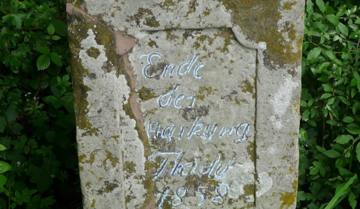 Ein verwitterter Grenzstein mit der Inschrift 'Ende des ... Thale 1858', umgeben von üppigem Grün., © Natur.Nah. Schönbuch & Heckengäu Ein verwitterter Grenzstein mit der Inschrift 'Ende des ... Thale 1858', umgeben von üppigem Grün., © Natur.Nah. Schönbuch & Heckengäu