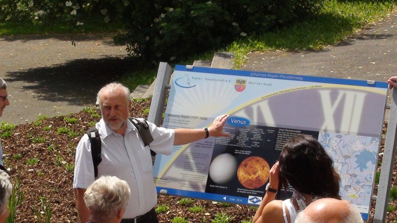 Ein Mann zeigt einer Gruppe ein Schild &uuml;ber Venus auf dem Johannes-Kepler-Planetenweg. Die Gruppe h&ouml;rt aufmerksam zu., &copy; Natur.Nah. Sch&ouml;nbuch & Heckeng&auml;u