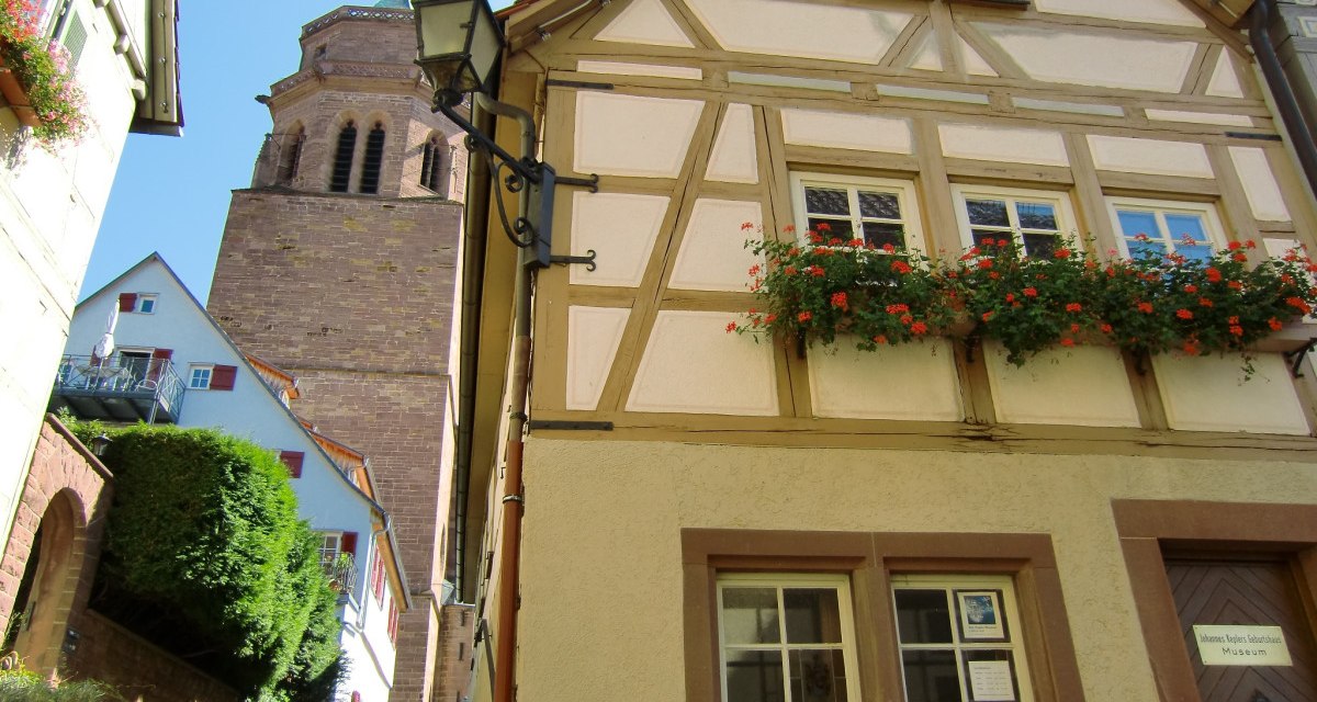 Fachwerkhaus mit blühendem Blumenkasten, daneben ein Kirchturm. Treppen führen zwischen den Gebäuden hinauf. Klarer blauer Himmel im Hintergrund., © Natur.Nah. Schönbuch & Heckengäu Fachwerkhaus mit blühendem Blumenkasten, daneben ein Kirchturm. Treppen führen zwischen den Gebäuden hinauf. Klarer blauer Himmel im Hintergrund., © Natur.Nah. Schönbuch & Heckengäu