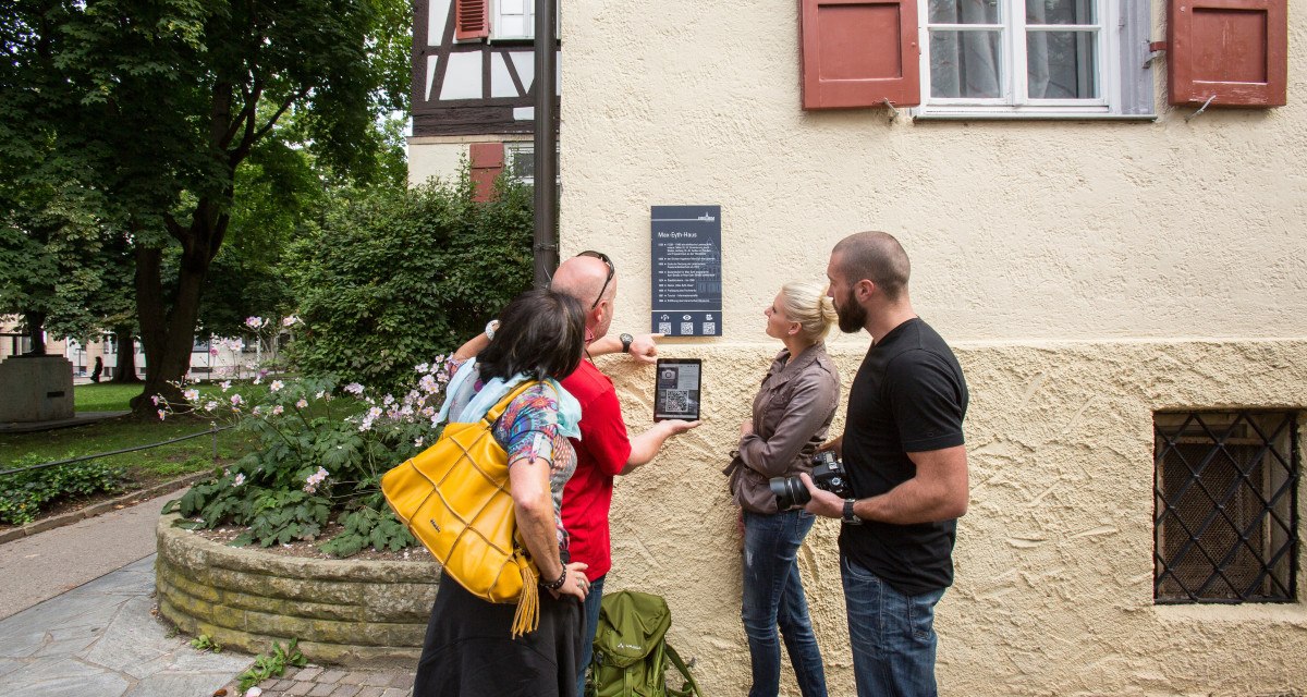 Vier Personen stehen vor dem Max-Eyth-Haus und betrachten eine Infotafel mit QR-Code. Eine Person hält ein Tablet, um den Code zu scannen., © Stadt Kirchheim unter Teck
