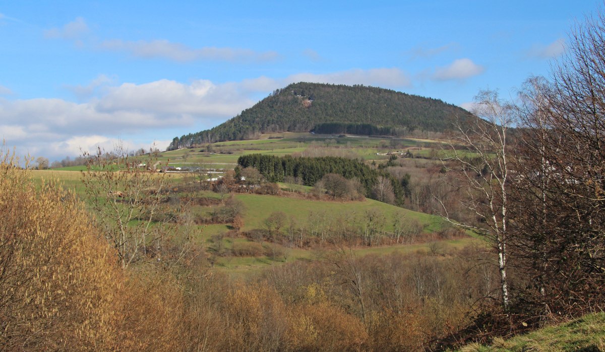 Der Berg Stuifen erhebt sich in einer grünen Landschaft mit Wiesen und Bäumen unter einem blauen Himmel., © Foto: Hans-Werner Kalb