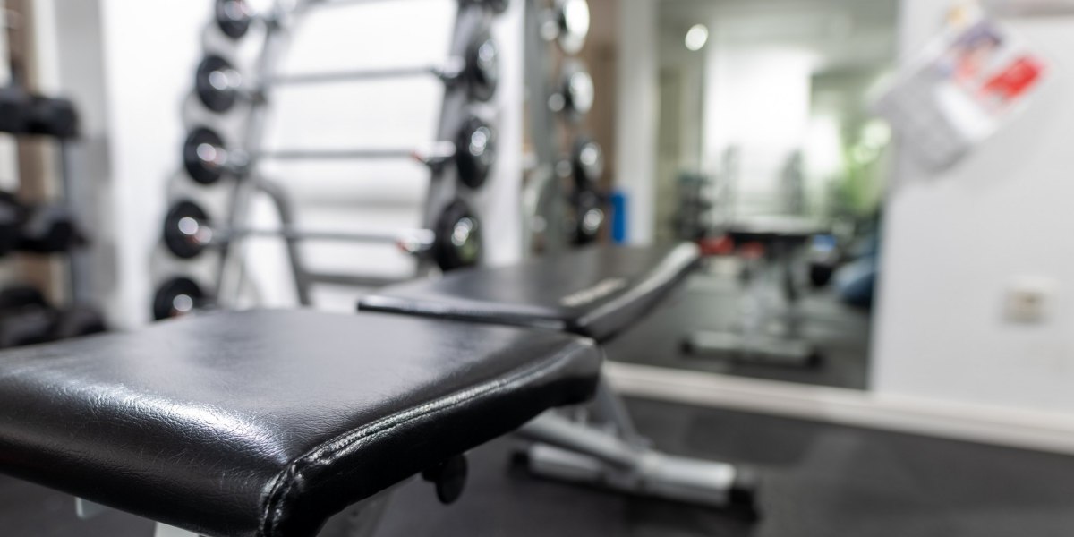 Ein Fitnessstudio mit einer schwarzen Trainingsbank im Vordergrund und Hanteln im Hintergrund., © Hotel Princess