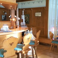 Holzvert&auml;felte Bar mit rustikalen St&uuml;hlen und Tisch im Erikson Hotel. Dekorative Bilder und Flaschen auf der Theke, gem&uuml;tliche Atmosph&auml;re., &copy; Erikson Hotel Sindelfingen