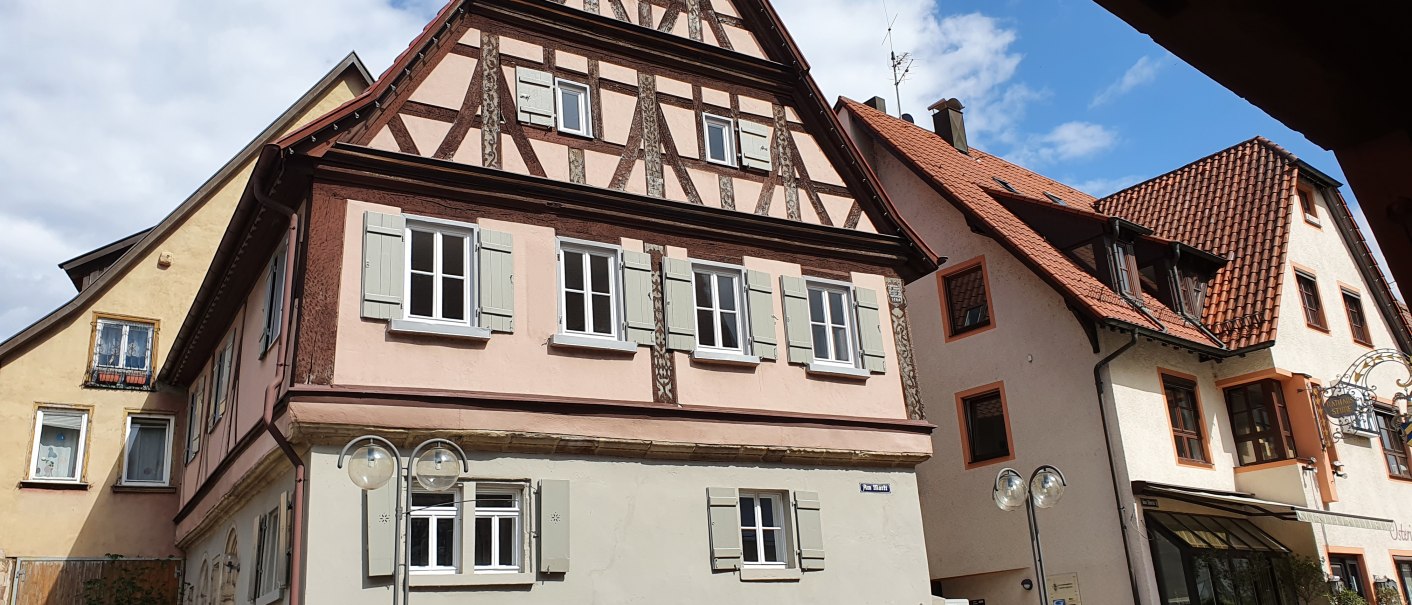 Fachwerkhaus in einer Altstadt, umgeben von weiteren historischen Gebäuden. Der Himmel ist blau mit einigen Wolken., © PlochingenInfo