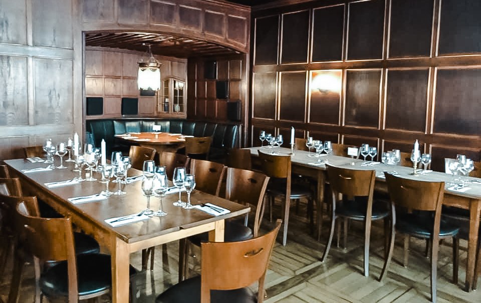 Elegantes Restaurant mit Holzwänden, gedeckten Tischen und Kerzenlicht. Dunkle Holzmöbel und eine gemütliche Atmosphäre dominieren den Raum., © Weinstube Fröhlich Verwaltungs GmbH Elegantes Restaurant mit Holzwänden, gedeckten Tischen und Kerzenlicht. Dunkle Holzmöbel und eine gemütliche Atmosphäre dominieren den Raum., © Weinstube Fröhlich Verwaltungs GmbH