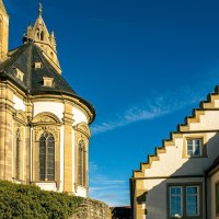 Die Gro&szlig;comburg in Schw&auml;bisch Hall zeigt beeindruckende Architektur mit einem Turm und einem Geb&auml;ude mit Treppengiebel unter klarem, blauem Himmel., &copy; Stuttgart-Marketing GmbH, Sarah Schmid
