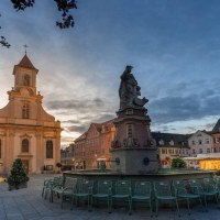 Abendstimmung auf einem Platz in Ludwigsburg. Eine Kirche und ein Brunnen sind im Vordergrund, umgeben von historischen Geb&auml;uden und St&uuml;hlen., &copy; &copy; Martina Denker