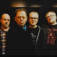 Vier Männer posieren vor einem dunklen Hintergrund. Sie tragen lässige Kleidung und blicken ernst in die Kamera., © links im Bild Vier Männer posieren vor einem dunklen Hintergrund. Sie tragen lässige Kleidung und blicken ernst in die Kamera., © links im Bild