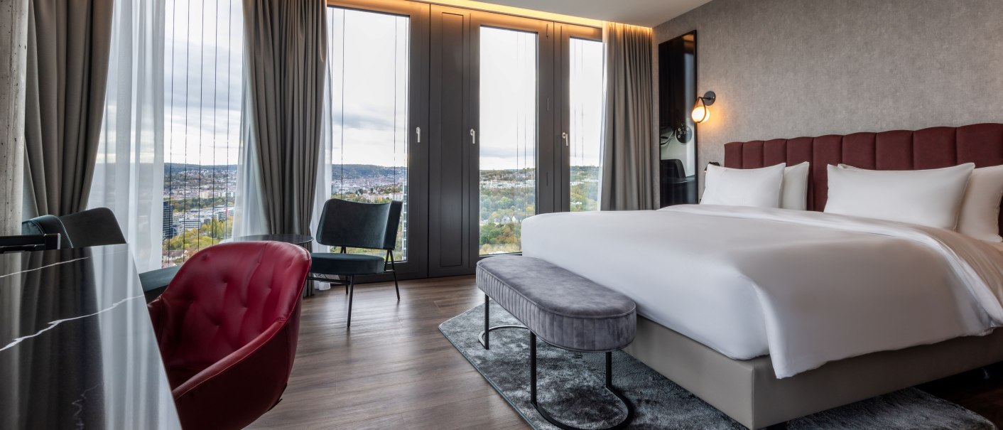 Modernes Hotelzimmer mit großem Bett, Panoramafenstern, stilvoller Einrichtung und Blick auf die Stadt., © Radisson Hotel Group
