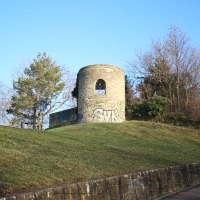 Eine alte, runde Ruine mit Graffiti steht auf einem grasbewachsenen H&uuml;gel, umgeben von kahlen B&auml;umen und blauem Himmel., &copy; SMG
