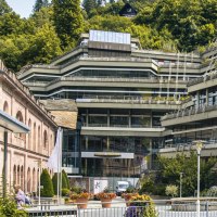 Modernes Gebäude mit Terrassen und Glasfronten, umgeben von Bäumen. Im Vordergrund Blumen und ein Brunnen., © Stuttgart-Marketing GmbH, Sarah Schmid