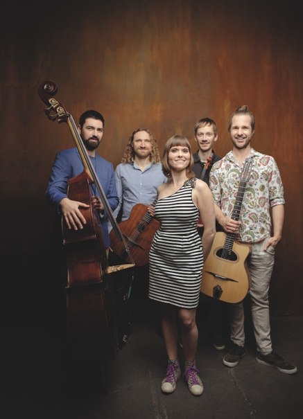 Eine f&uuml;nfk&ouml;pfige Musikgruppe posiert vor einem braunen Hintergrund. Die Mitglieder halten Instrumente und l&auml;cheln in die Kamera., &copy; Kulturstiftung Hohenlohe