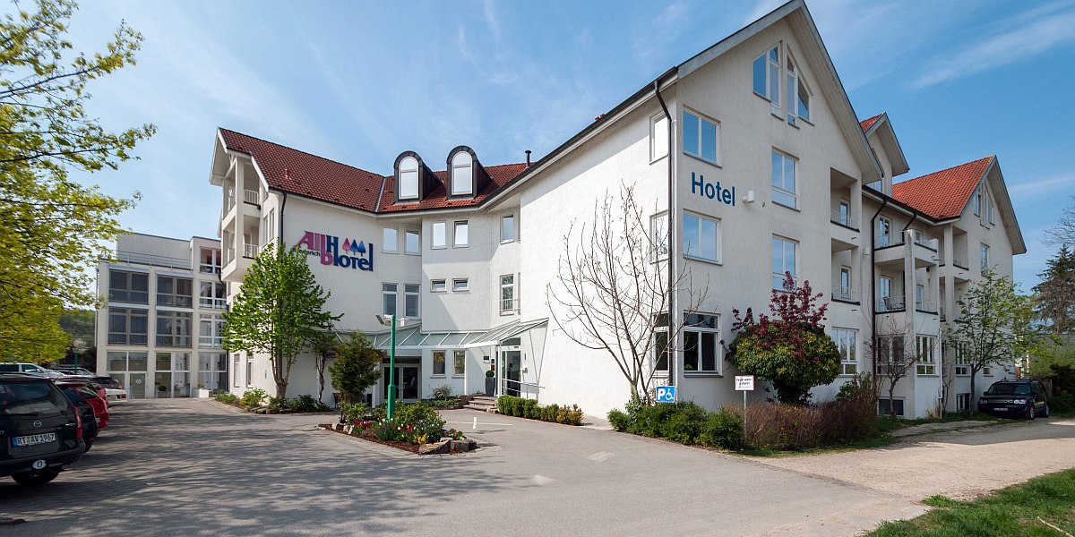 Das Albhotel Fortuna ist ein weißes Gebäude mit rotem Dach, umgeben von Bäumen und einem Parkplatz. Der Himmel ist blau und klar., © Albhotel Fortuna
