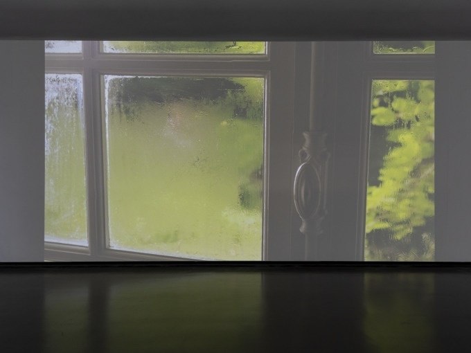 Ein projiziertes Bild zeigt ein Fenster mit unscharfem Blick auf gr&uuml;ne Vegetation in einem dunklen Raum., &copy; Kunsthalle G&ouml;ppingen