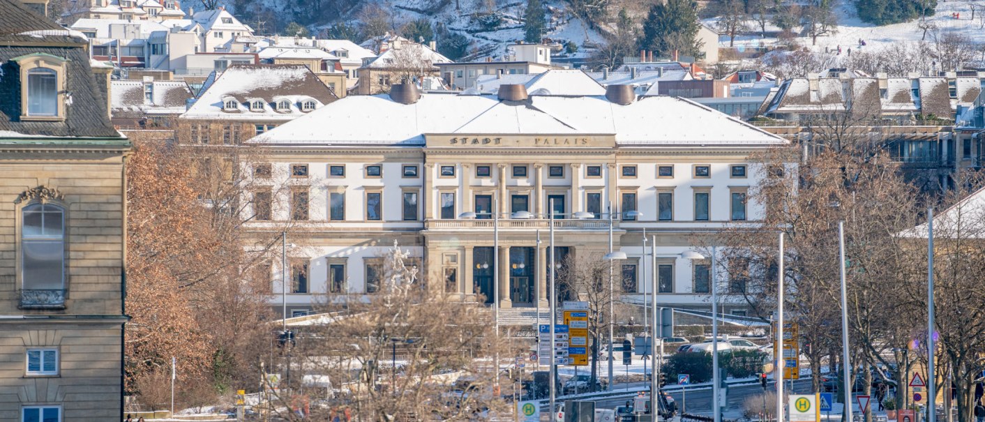 Das StadtPalais in Stuttgart ist im Winter zu sehen, mit schneebedecktem Dach und umliegenden Gebäuden. Bäume ohne Blätter im Vordergrund., © SMG Thomas Niedermüller Das StadtPalais in Stuttgart ist im Winter zu sehen, mit schneebedecktem Dach und umliegenden Gebäuden. Bäume ohne Blätter im Vordergrund., © SMG Thomas Niedermüller