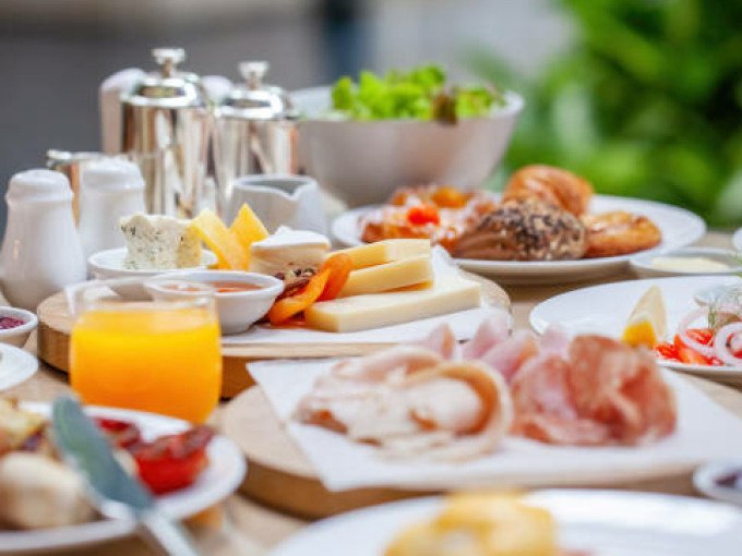 Ein reichhaltiger Brunch mit Käse, Aufschnitt, Croissants und Orangensaft auf einem Tisch im Freien., © Cool-Tours StattReisen