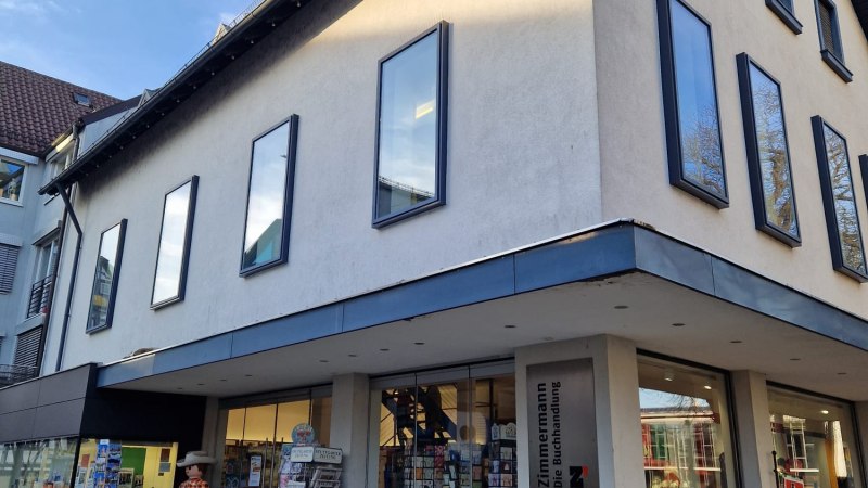 Die Buchhandlung Zimmermann zeigt eine moderne Fassade mit gro&szlig;en Fenstern. Vor dem Eingang stehen Tische mit B&uuml;chern zum Verkauf., &copy; cStadtNuertingen