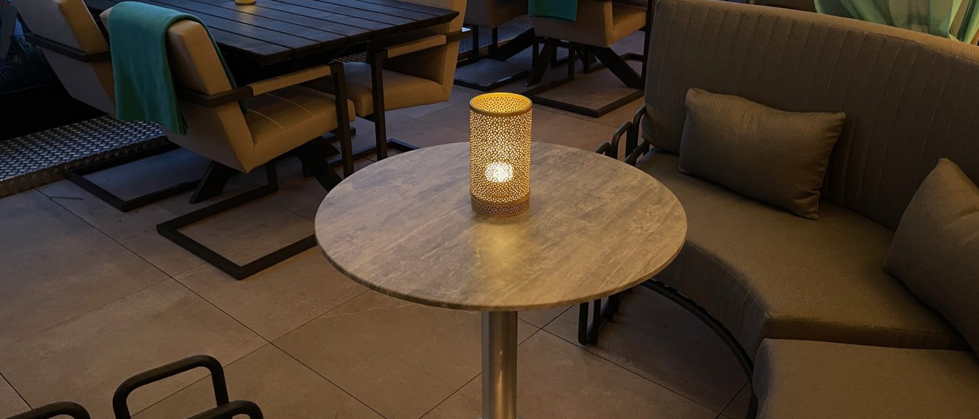 Gem&uuml;tliche Dachterrasse mit modernen Sitzgelegenheiten und Kerzenlicht. Im Hintergrund ist ein Geb&auml;ude mit der Aufschrift 'TRESOR' zu sehen., &copy; Lunar