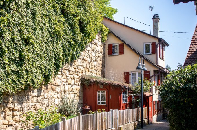 Ein idyllischer Weg in Schw&auml;bisch Gm&uuml;nd mit einem charmanten Haus, roten Fensterl&auml;den und einer efeubewachsenen Steinmauer., &copy; Touristik und Marketing GmbH