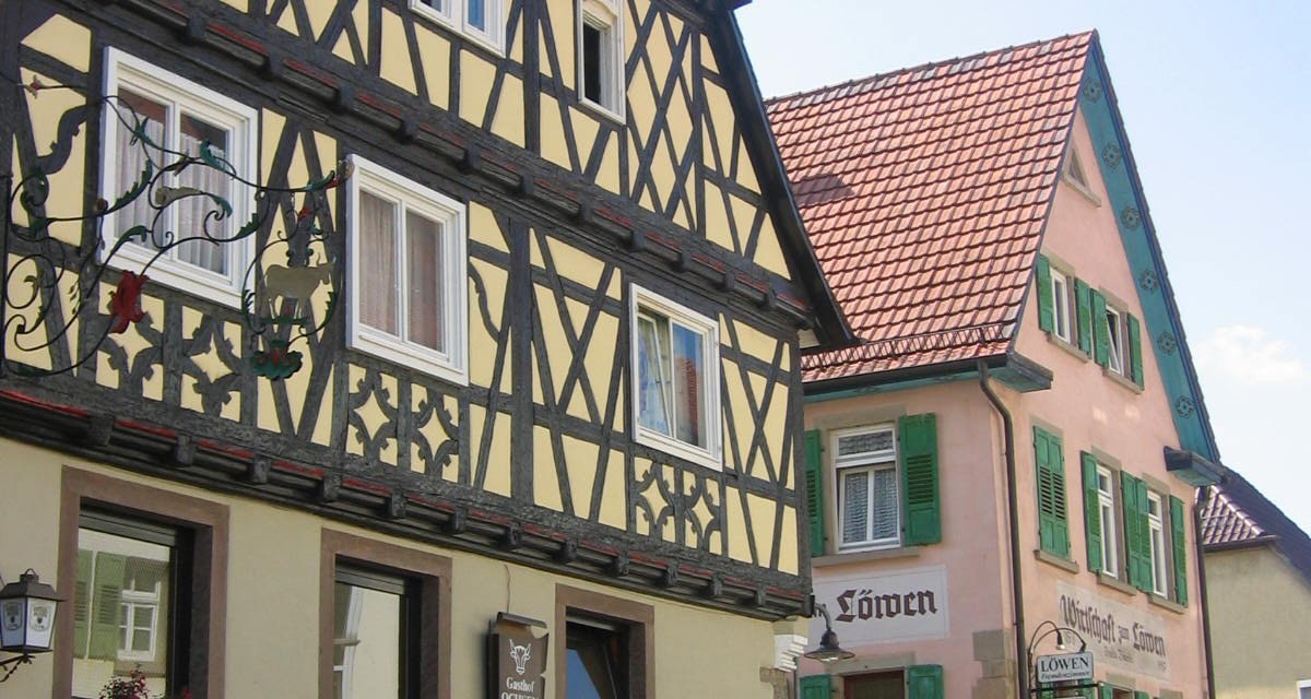 Fachwerkh&auml;user in einer deutschen Stadt. Links das Gasthaus 'Zum Ochsen', rechts 'Zum L&ouml;wen'. Beide Geb&auml;ude haben bunte Fensterl&auml;den., &copy; Land der 1000 H&uuml;gel - Kraichgau-Stromberg