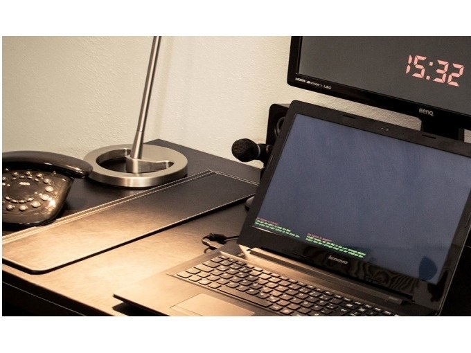 Schreibtisch mit Laptop, Tischlampe, altem Telefon und Monitor, der 15:32 anzeigt., © TeamEscape Stuttgart Schreibtisch mit Laptop, Tischlampe, altem Telefon und Monitor, der 15:32 anzeigt., © TeamEscape Stuttgart