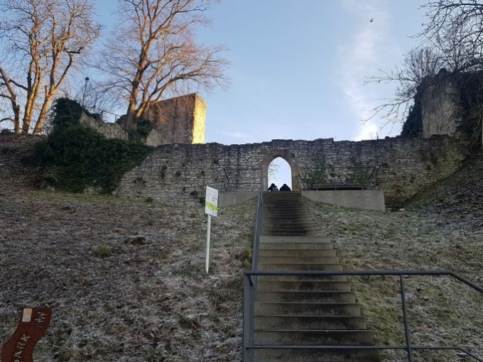 Steintreppe f&uuml;hrt zu einer alten Burgmauer mit Torbogen, umgeben von kahlen B&auml;umen und leichtem Frost., &copy; Cool-Tours StattReisen