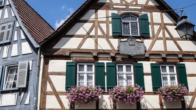 Zwei Fachwerkhäuser in der Altstadt von Marbach am Neckar. Eines hat grüne Fensterläden und Blumenkästen, das andere blaue Fensterläden., © SMG Antje Seeling Zwei Fachwerkhäuser in der Altstadt von Marbach am Neckar. Eines hat grüne Fensterläden und Blumenkästen, das andere blaue Fensterläden., © SMG Antje Seeling
