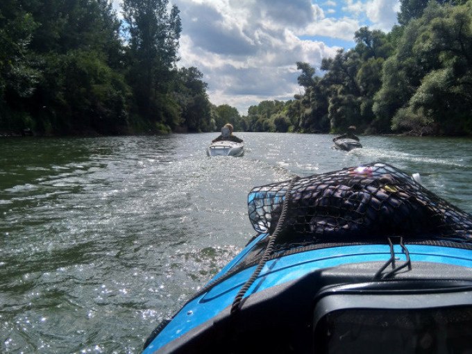 Zwei Boote fahren auf einem Fluss, umgeben von üppigen Bäumen. Der Himmel ist bewölkt, und die Szene wirkt ruhig und idyllisch., © Cool-Tours StattReisen Zwei Boote fahren auf einem Fluss, umgeben von üppigen Bäumen. Der Himmel ist bewölkt, und die Szene wirkt ruhig und idyllisch., © Cool-Tours StattReisen