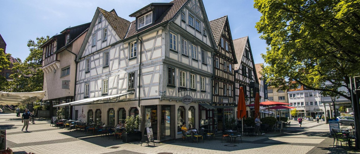 Backnang Altstadt Fachwerk: Fachwerkhäuser in der Backnanger Altstadt mit Caféterrassen an einem sonnigen Platz., © SMG, Sarah Schmid Backnang Altstadt Fachwerk: Fachwerkhäuser in der Backnanger Altstadt mit Caféterrassen an einem sonnigen Platz., © SMG, Sarah Schmid