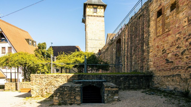 Blick auf eine historische Burgmauer und ein Fachwerkgebäude in Marbach am Neckar. Der Himmel ist klar und blau., © Stuttgart-Marketing GmbH, Sarah Schmid