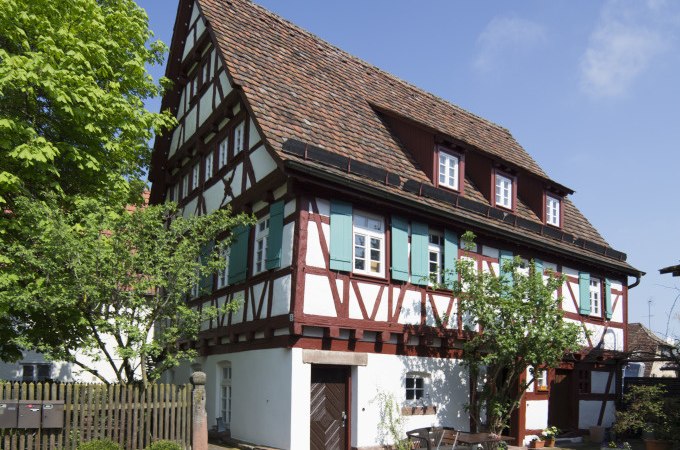 Fachwerkhaus mit grünen Fensterläden, umgeben von Bäumen und Gartenmöbeln. Sonniger Tag mit blauem Himmel., © Stadtverwaltung Weil der Stadt Fachwerkhaus mit grünen Fensterläden, umgeben von Bäumen und Gartenmöbeln. Sonniger Tag mit blauem Himmel., © Stadtverwaltung Weil der Stadt