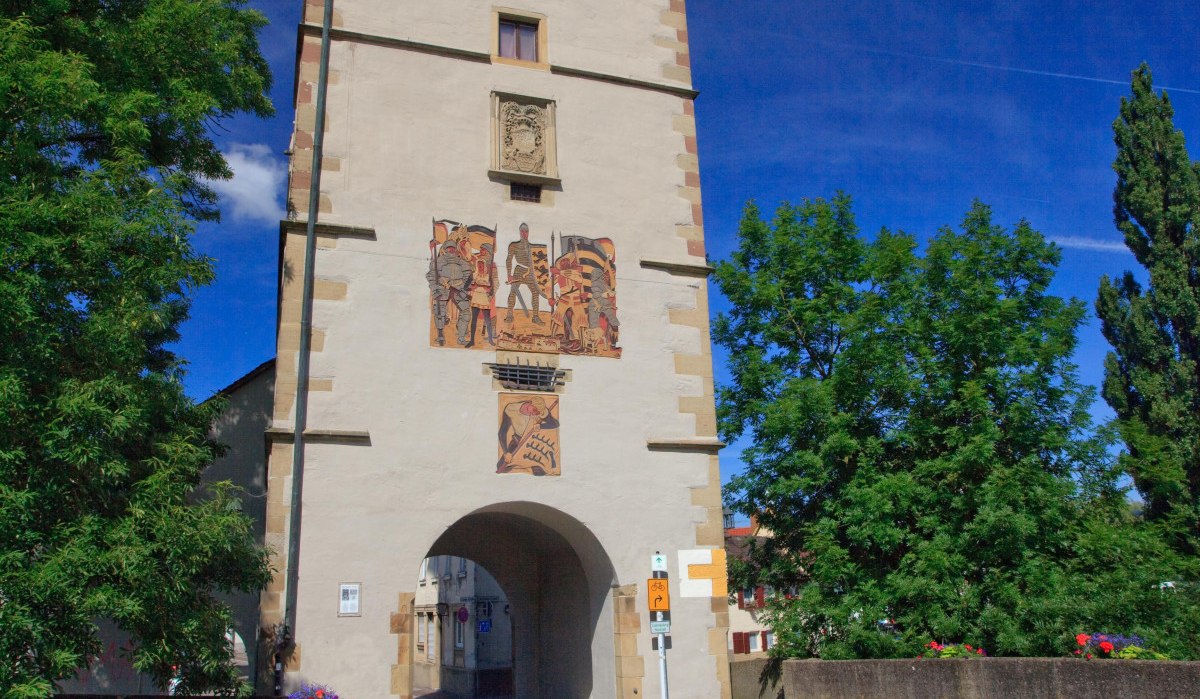 Der Beinsteiner Torturm erhebt sich majestätisch unter einem klaren blauen Himmel. Bunte Blumen schmücken die Brücke im Vordergrund., © Waiblingen - Stuttgart-Marketing GmbH Der Beinsteiner Torturm erhebt sich majestätisch unter einem klaren blauen Himmel. Bunte Blumen schmücken die Brücke im Vordergrund., © Waiblingen - Stuttgart-Marketing GmbH
