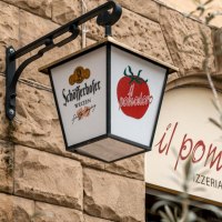 Ein Schild mit Sch&ouml;fferhofer-Logo und Tomatenmotiv h&auml;ngt an einer Steinwand vor dem Restaurant 'il pomodoro'., &copy; SMG, Sarah Schmid